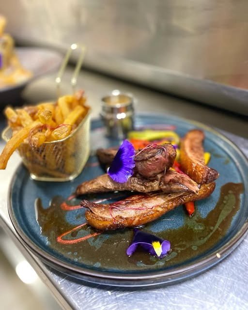 Viande grillée, frites maison et fleurs comestibles